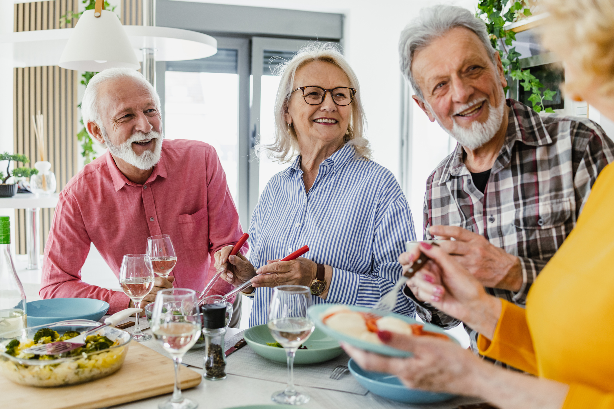 Photo of a senior group of friends having lunch and hanging out at home