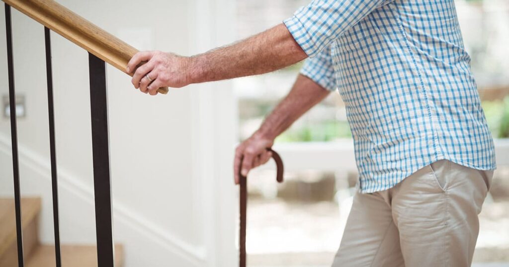 Photo of a senior holding a railing