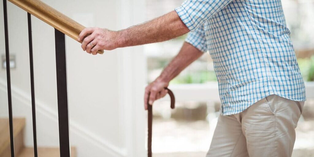 Photo of a senior holding a railing