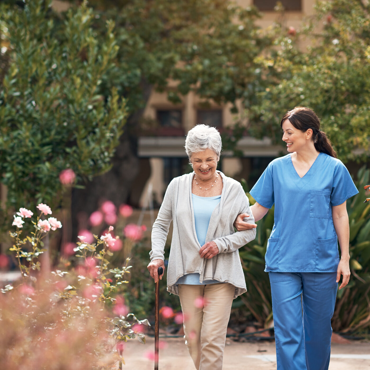 Shot of a caregiver and her patient out for a walk in the garden